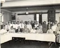 Group of men seated around a table at what appears to be the grand opening celebration in the 1950s, with the Dearborn mayor in attendance