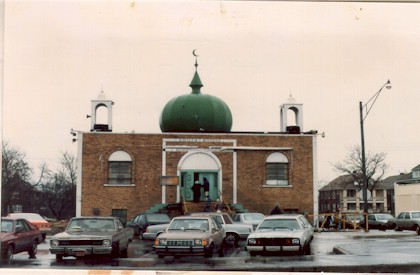 Front view of the full AMS building before major expansions, featuring a green dome and two small minarets